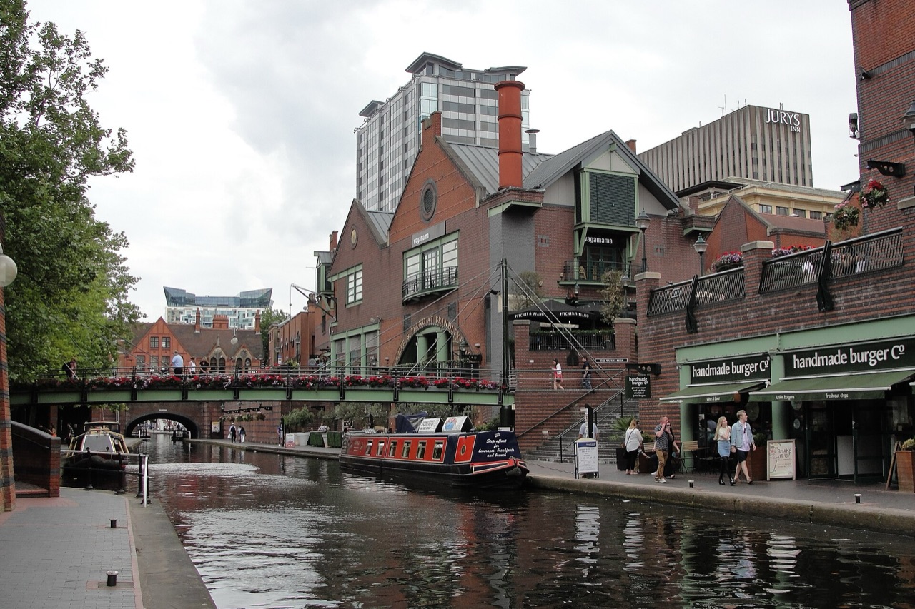 The canal at Brindleyplace in Birmingham, with a narrowboat, footbridge and canalside bars and restaurants