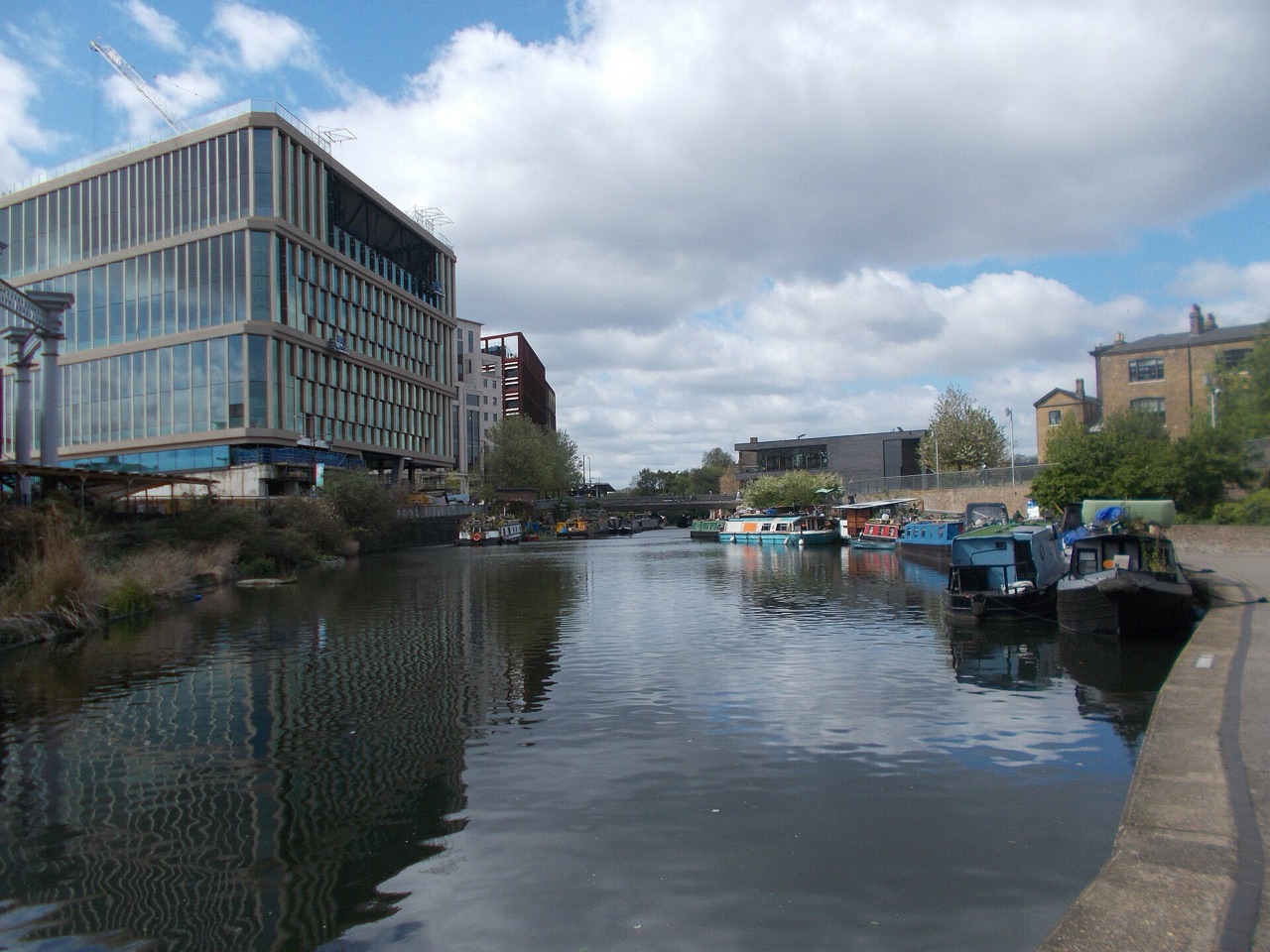 Narrowboats moored on the Regent's Canal at King's Cross, with modern office buildings along the towpath