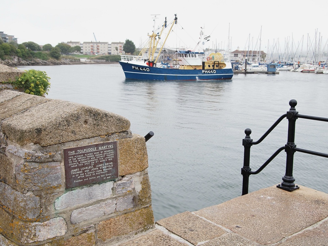 A fishing boat in the harbour at the Barbican in Plymouth, seen from the stone quayside