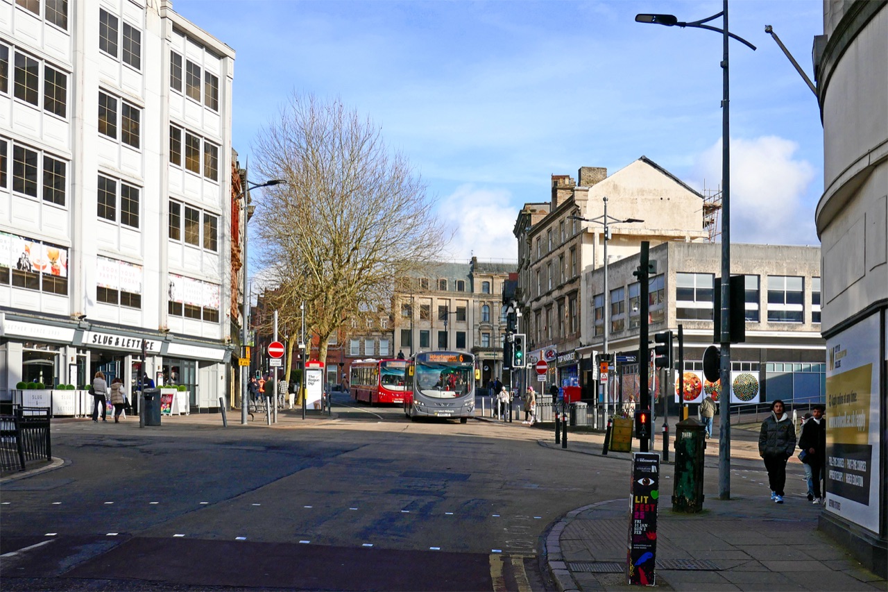 Darlington Street meeting Queen Square in Wolverhampton city centre, with shops and a bus